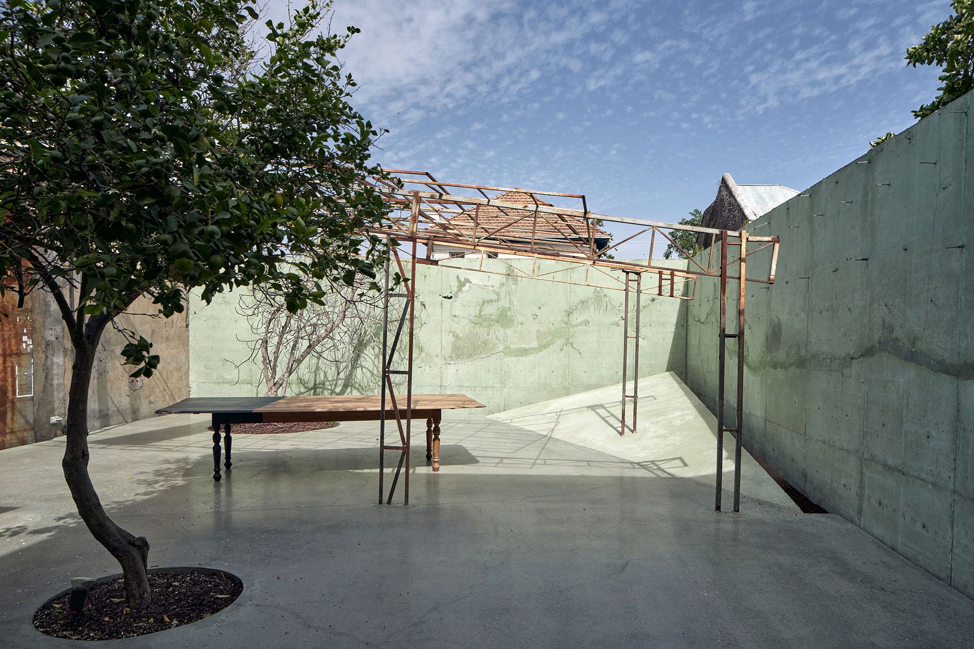 El patio: muros de hormigón verde y la estructura de fierro de la antigua nave.